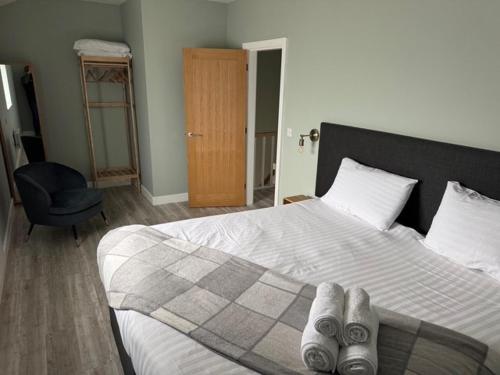 a bedroom with a bed with two pairs of shoes on it at Oakwood Farm Barns in Chester