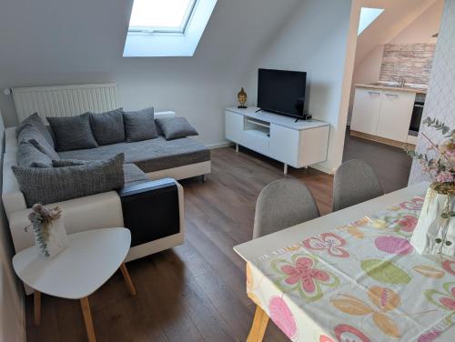 a living room with a couch and a tv at FeWo Luzia in Losheim