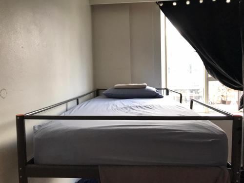 a bed in a small room with a window at Zen Hostel in Toronto