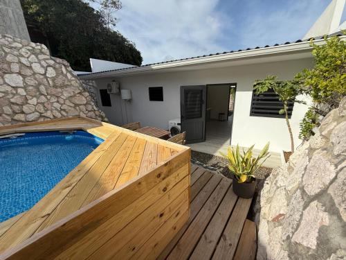 a pool on a wooden deck next to a house at Boho Garden Jan Thiel Apt C in Jan Thiel