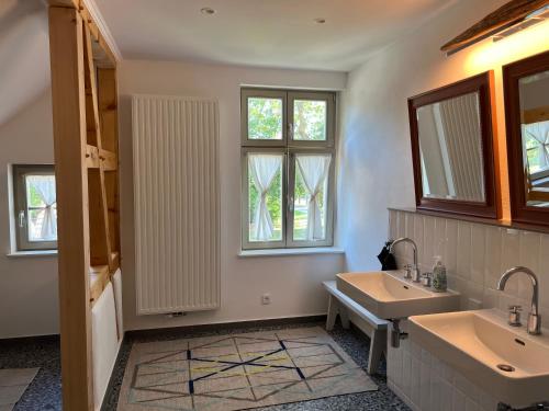 a bathroom with two sinks and two windows at Forsthaus Barsdorf in Fürstenberg