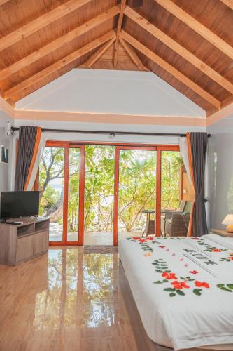 a bedroom with a large bed and a television at Sabba Beach Suite , Fodhdhoo - Maldives in Velidhoo
