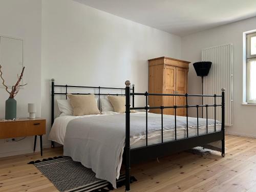 a bedroom with a black bed and a dresser at Forsthaus Barsdorf in Fürstenberg