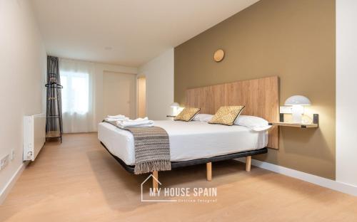 ein Schlafzimmer mit einem großen Bett mit einem hölzernen Kopfteil in der Unterkunft MyHouseSpain - Edificio Vanguardia in Gijón