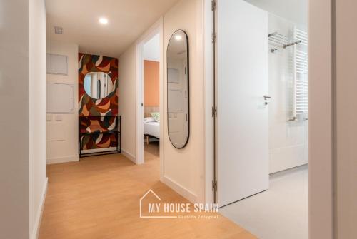einen Flur mit einem Spiegel und einem Ankleidezimmer in der Unterkunft MyHouseSpain - Edificio Vanguardia in Gijón