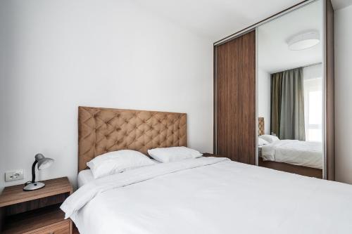 a bedroom with a large bed and a large mirror at Status-M Apartments 187 in Becici