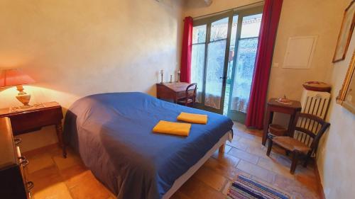 a bedroom with a bed and a desk and a window at Maison de Village en Camargue Parking Clim Wifi - ROSSIconciergerie - Linge inclus in Saint-Laurent-dʼAigouze