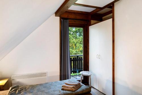 a bedroom with a bed and a large window at Ferienhaus am Silbersee Frielendorf in Frielendorf