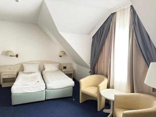a hotel room with a bed and a desk and chair at HOTEL S Norderstedt in Norderstedt