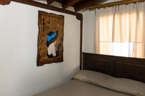 ein Schlafzimmer mit einem Bett und einem Gemälde an der Wand in der Unterkunft illia in Maroneia
