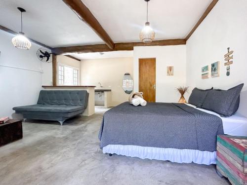 a bedroom with a bed and a couch at Pousada Aimê Maresias in São Sebastião