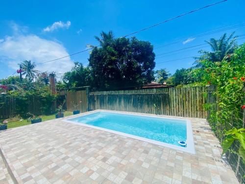 a swimming pool in a backyard with a fence at Casa Aruanã - Praia do Sargi, Serra Grande in Uruçuca