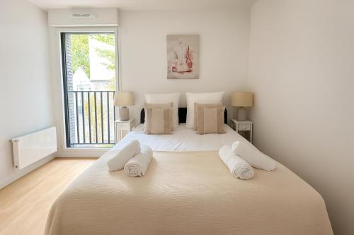 ein weißes Schlafzimmer mit einem großen Bett mit drei Kissen in der Unterkunft Spacieux 3 chambres et lumineux à Montrouge in Malakoff
