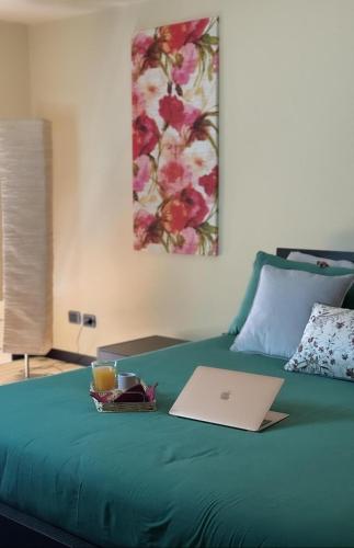 a laptop computer sitting on top of a green bed at Giacarda Suite in Salerno