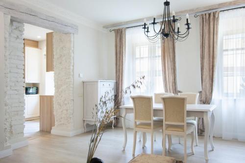 a dining room with a white table and chairs at Apartments Satva in Vilnius
