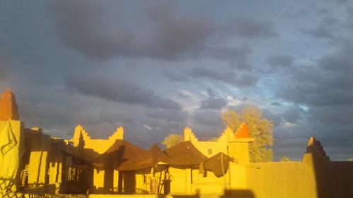 a group of buildings under a cloudy sky at Kasbah Dar Dmana in Skoura