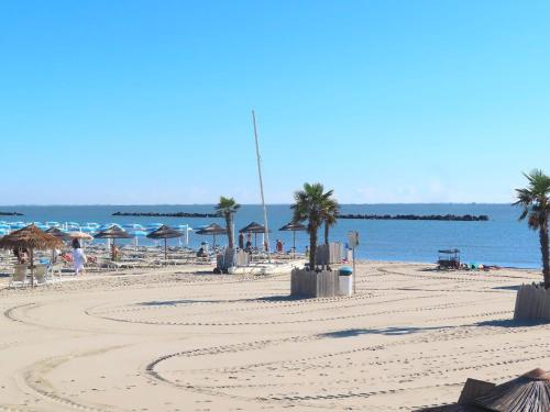 a beach with trees and umbrellas and the ocean at Searoom in Lido delle Nazioni