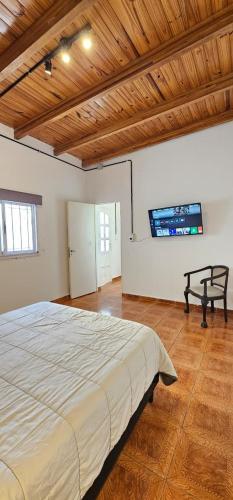 a bedroom with a large bed and a wooden ceiling at LitStay Monoambiente in Córdoba