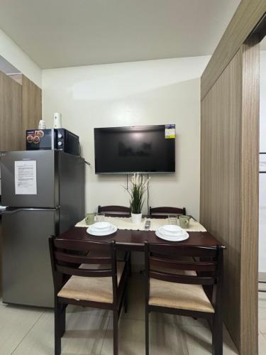Un comedor con una mesa y un refrigerador. en SHORE Staycation in MOA by MLG, en Manila