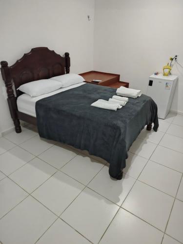 a bedroom with a bed with two towels on it at Quarto Feliz in Belém