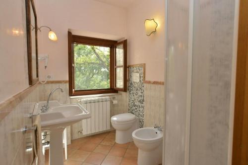 a bathroom with a sink and a toilet and a window at Historic Farmhouse In The Tuscan Hills in Caprese Michelangelo