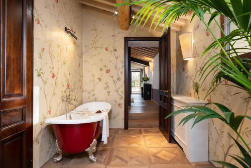 a bathroom with a bath tub and a plant at Fattoria di Vegi in Castellina in Chianti