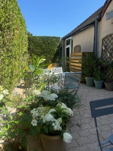 a patio with chairs and white flowers and plants at Hôtel Kyriad Epernay en Champagne in Épernay