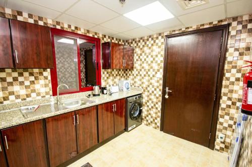 a kitchen with a sink and a washing machine at Fully Furnished Brand new 1BHK at Warsan in Dubai