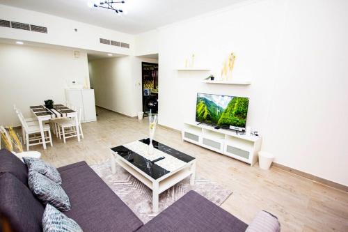 a living room with a couch and a flat screen tv at Fully Furnished Brand new 1BHK at Warsan in Dubai
