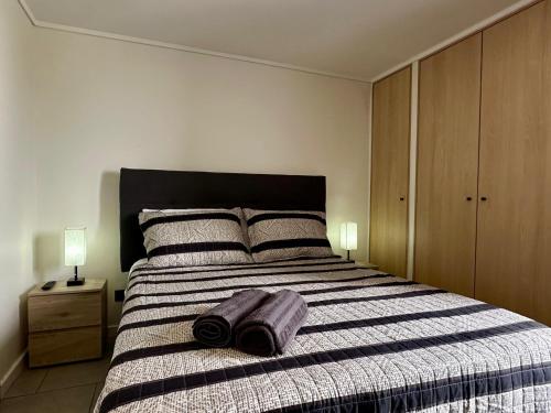 Un dormitorio con una cama grande con una manta a rayas. en Estudio cerca del Movistar Arena, en Santiago