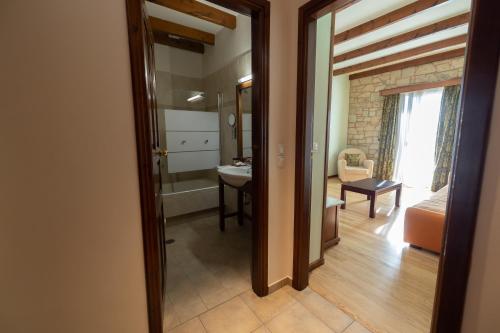 a room with a door open to a room with a bathroom at Alpen House Hotel & Suites in Arachova