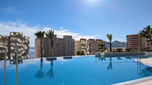 a large swimming pool in a city with buildings at SUNSET CLIFFS fantastic apartment in Benidorm