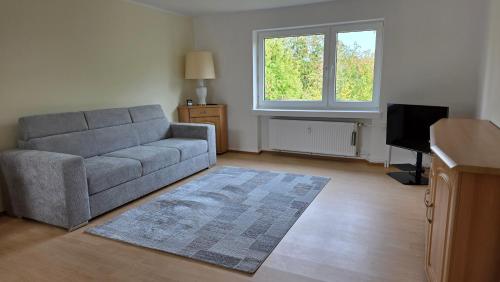 Una sala de estar con un sofá y un televisor. en Haus 21, en Bad Nenndorf