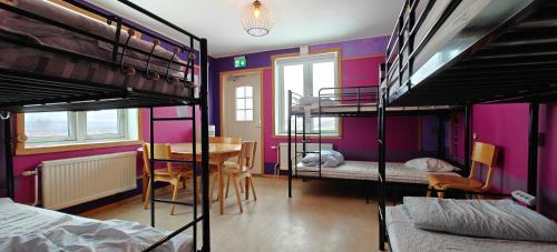 a room with two bunk beds and a table and chairs at Abisko net Hostel & Huskies in Abisko