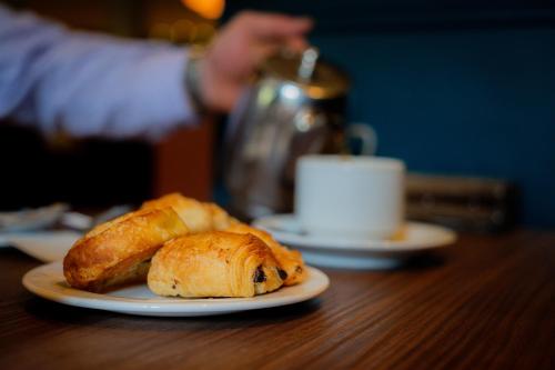 Un plato de pan y croissants en una mesa en The Malone Hotel, en Belfast