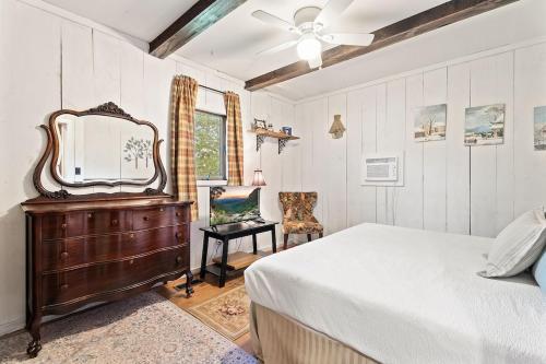 a bedroom with a bed and a mirror and a chair at Rustic Cabin Getaway Close to Everything Fun! in Beaver Dams