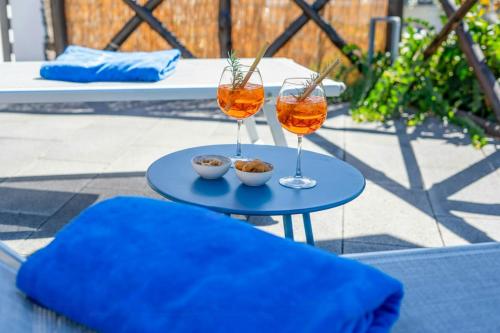 Mediterranean House With Amalfi Coast View في Colli di Fontanelle: كأسين من النبيذ يجلسون على طاولة زرقاء