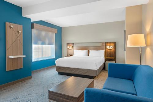 a hotel room with a bed and a couch at Holiday Inn Express & Suites Indianapolis - East by IHG in Indianapolis