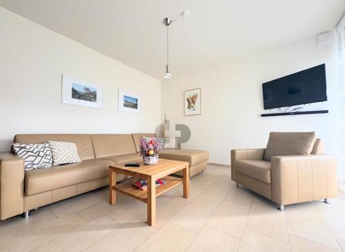 a living room with two couches and a table at WINDLICHT App Nr 3 max 4 Pers in Dierhagen