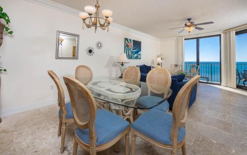 Phoenix X 1513 condo في شاطئ أورانج: غرفة طعام مع طاولة وكراسي زجاجية