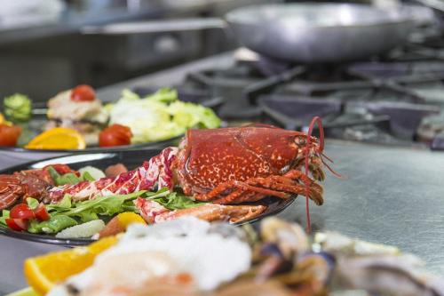 a lobster on a plate of food on a stove at Hotel Mara in Ortona