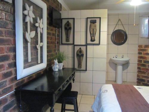 a bedroom with a table and a sink in a room at Pumba's B&B in Sannieshof