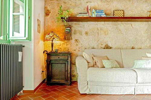 a living room with a white couch and a table at 16Th Century Farmhouse Between The Tuscan Hills in Brancorsi