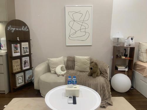 a living room with a chair and a table at Vinhomes Smart City by Chill D Homestay in Phú Thú