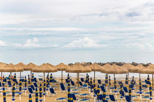 a bunch of chairs and umbrellas on a beach at Hotel Mara in Ortona