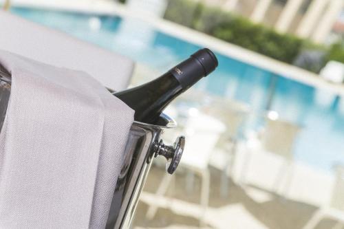a bottle of wine in a trash can next to a pool at Hotel Mara in Ortona