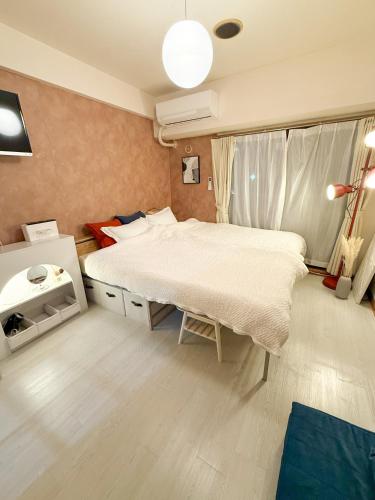 a bedroom with a large bed and a window at Omori 8min Stylish and comfortable room in Tokyo