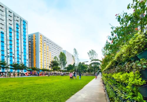 Gente caminando por una acera en un parque con edificios. en Urban Stay with Netflix KTV Wifi and Gym Park, en Manila