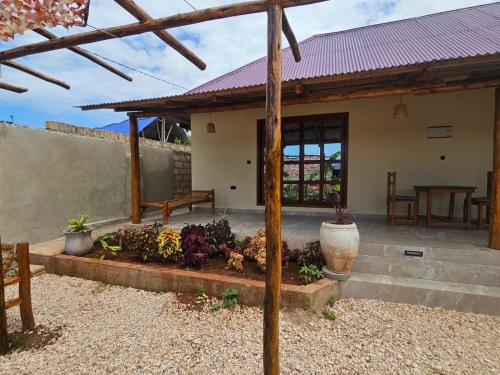 a patio of a house with a bench and flowers at Morena villa in Kendwa