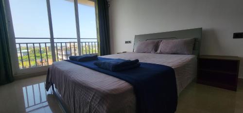 Un dormitorio con una cama con una manta azul encima. en 2bhk cozy apt near baina beach, en Vasco Da Gama